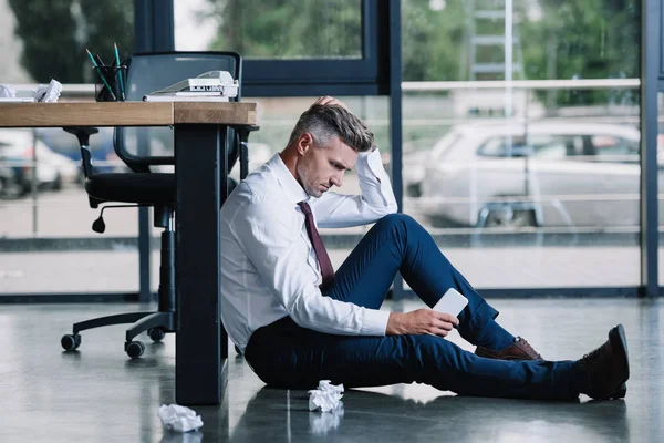 Handsome Businessman Sitting Floor Holding Smartphone Table Office Royalty Free Stock Images
