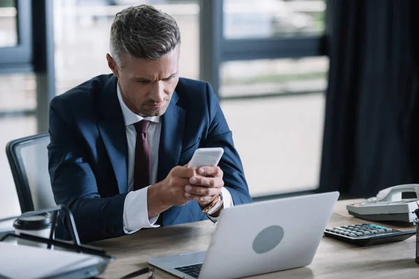 Hombre Negocios Guapo Usando Teléfono Inteligente Cerca Computadora Portátil Bandeja — Foto de Stock