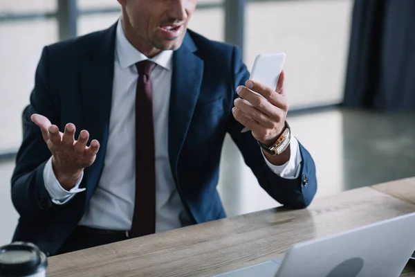 Ausgeschnittener Blick Auf Überraschten Geschäftsmann Mit Smartphone Und Gestik Laptopnähe — Stockfoto