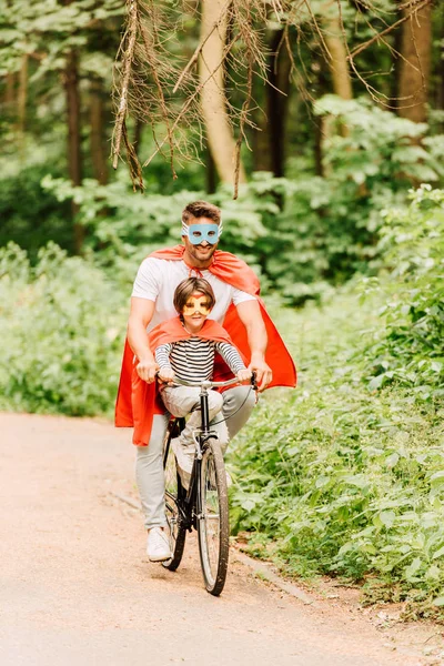 Visão Completa Pai Criança Andando Bicicleta Torno Floresta Trajes Super — Fotografia de Stock