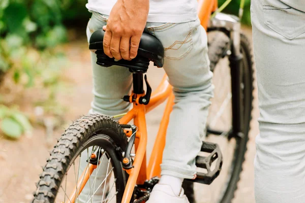 Visão Cortada Pai Segurando Sentar Bicicleta Para Ajudar Filho Montar — Fotografia de Stock