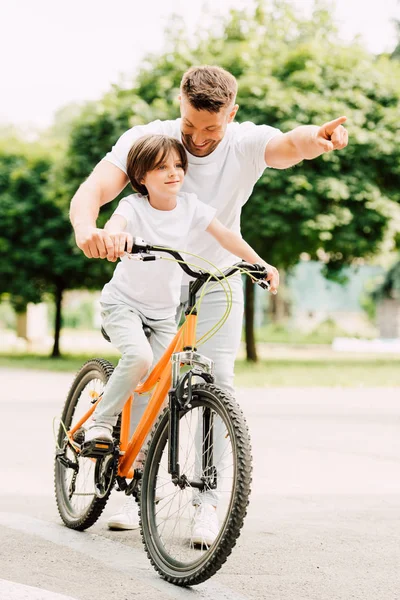 Vista Integrale Del Figlio Bicicletta Mentre Padre Punta Con Dito — Foto Stock