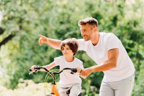 Син Їде Велосипеді Батько Допомагає Дитині Вказує Пальцем — стокове фото