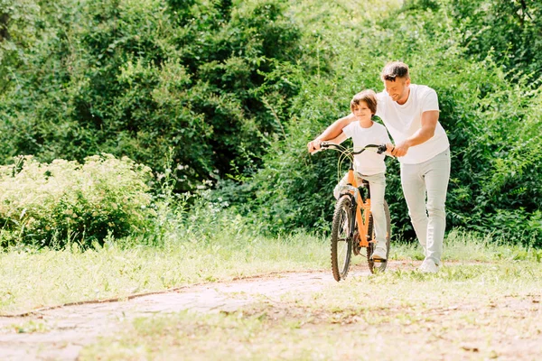 Visão Comprimento Total Pai Ajudando Filho Segurando Alças Bicicleta Enquanto — Fotografia de Stock