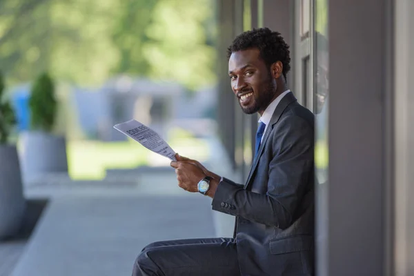 Knappe Afro Amerikaanse Zakenman Houdt Krant Glimlachend Camera — Stockfoto