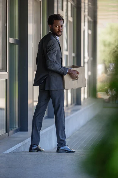 Selektywny Fokus Opalanych African American Biznesmen Patrząc Wstecz Trzymając Pudełko — Zdjęcie stockowe