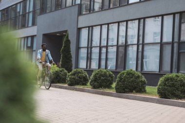 cam cepheile bina boyunca bisikletsürme Afrikalı Amerikalı adam seçici odak