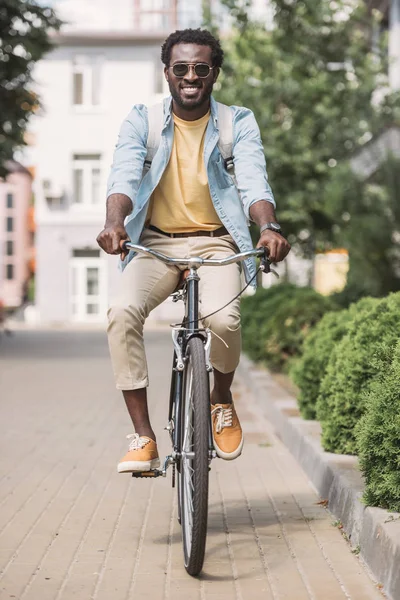 Alegre Afroamericano Hombre Ciclismo Largo Calle Soleada Sonriendo Cámara — Foto de Stock