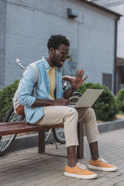 Vrolijke Afro Amerikaanse Man Zwaaiende Hand Terwijl Zittend Bank Tijdens — Stockfoto