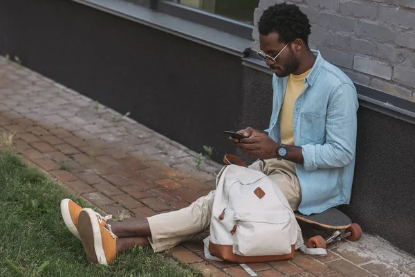 Bonito Elegante Homem Americano Africano Sentado Longboard Usando Smartphone — Fotografia de Stock