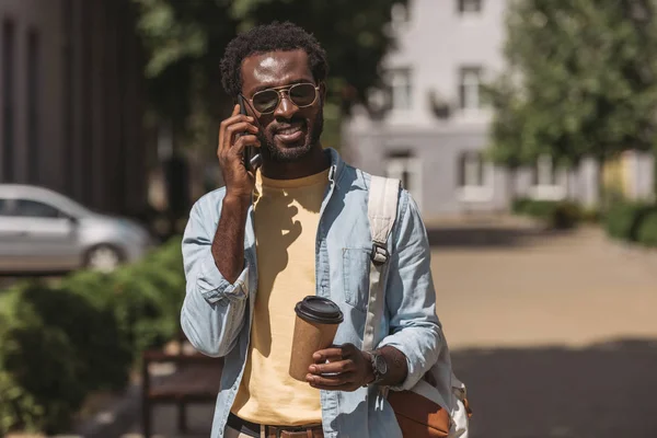 スマートフォンで話し 紙コップを持ってサングラスをかけたスタイリッシュなアフリカ系アメリカ人男性 — ストック写真