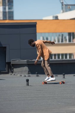 çatıda longboard sürme şık afrikalı Amerikalı işadamı