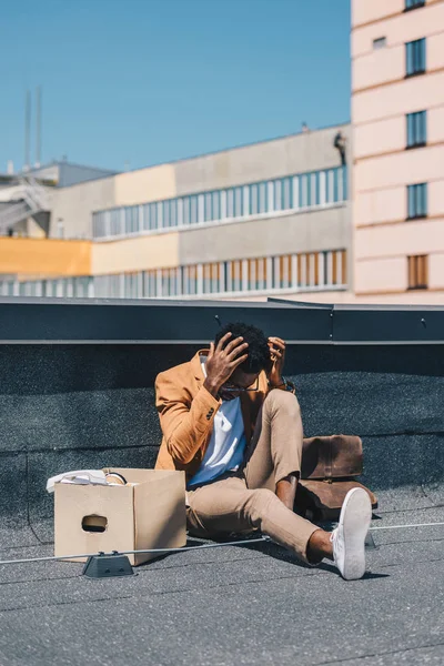 Hombre Negocios Afroamericano Deprimido Sentado Azotea Cerca Caja Cartón Cogido —  Fotos de Stock