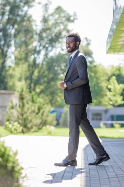 yakışıklı, neşeli afro-amerikan işadamı takım elbise kamera gülümseyerek 