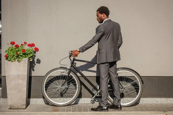 African American Businessman Suit Standing Bicycle Wall Red Flower Flowerpot — Stock Photo, Image