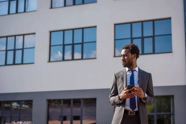 Selbstbewusster Afrikanisch Amerikanischer Geschäftsmann Schaut Weg Während Sein Smartphone Der — Stockfoto