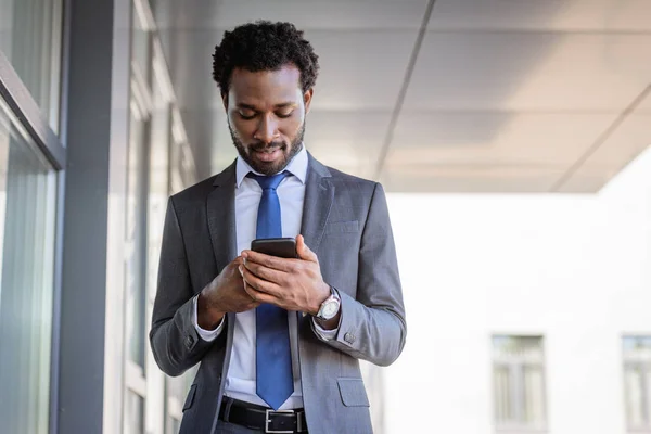 Snygg Afrikansk Amerikansk Affärsman Med Smartphone Stående Nära Kontorsbyggnad — Stockfoto