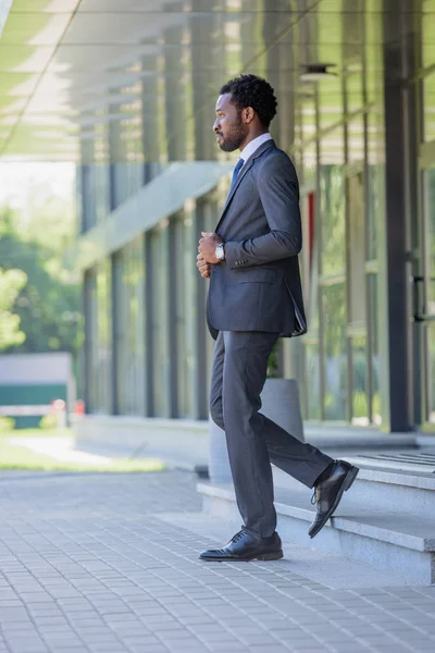 オフィスビルの階段を歩くスーツを着た自信のあるアフリカ系アメリカ人ビジネスマン — ストック写真