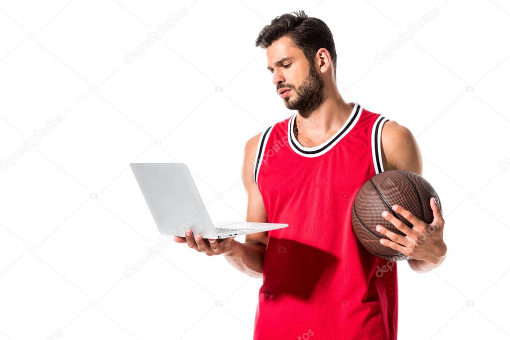 athletic basketball player in uniform with ball using laptop Isolated On White 