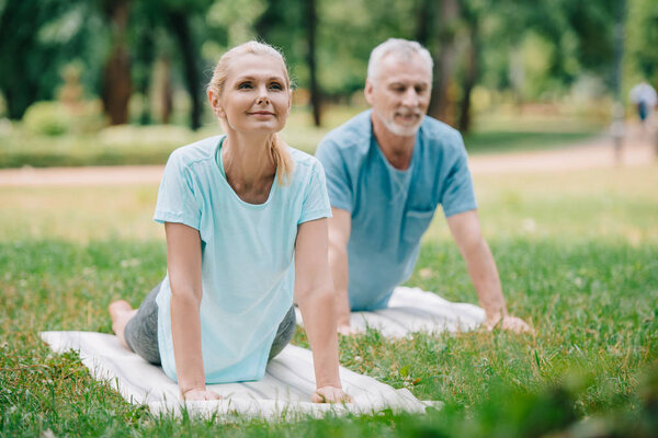 smiling man and woman practicing relaxation yoga poses on yoga mats