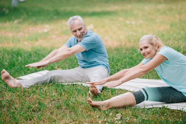 Leende Man Och Kvinna Öva Stretching Yogaställningarna När Sitter Yogamattor — Stockfoto