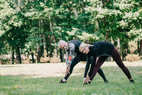 Mogen Sportsman Och Kvinna Leende Kameran Medan Utbildning Park Tillsammans — Stockfoto