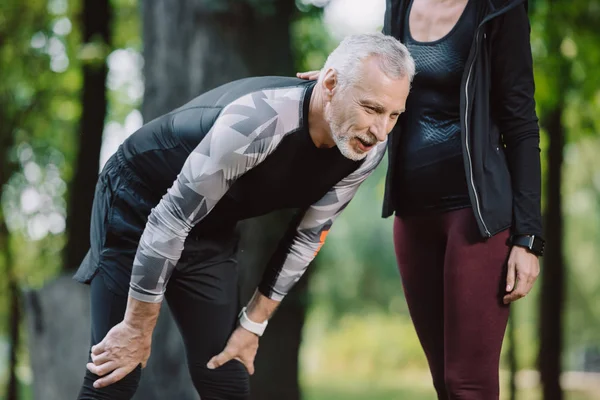 Beskuren Syn Kvinna Stående Nära Trött Mogen Sportsman Parken — Stockfoto