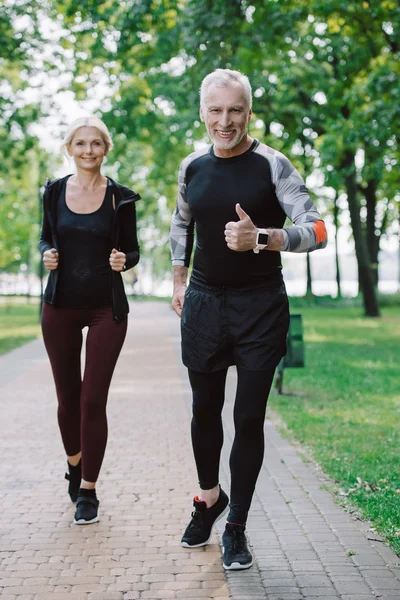 Leende Mogen Sportsman Visar Tummen Upp Medan Jogging Parken Tillsammans — Stockfoto