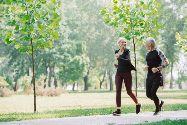 Fröhliche Reife Sportlerin Und Sportlerin Joggen Gemeinsam Sonnigen Park — Stockfoto