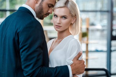 kapalı gözleri ile yakışıklı sakallı adam çekici sarışın kadın kamera bakarak sarılma
