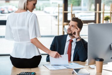 çekici kız masada oturan ve yakışıklı adam yakın çizelgeleri ve grafikler bakıyor 