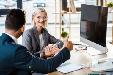 gözlük içinde neşeli kadın seçici odak ofiste başparmak yukarı gösteren adam bakıyor 
