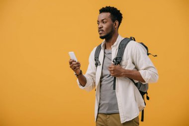 turuncu izole akıllı telefon tutan sırt çantası ile afrikalı amerikalı adam