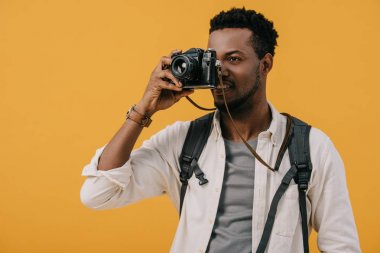turuncu izole dijital kamera ile yüz kapsayan afrikalı amerikalı adam