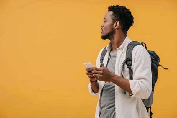 Bonito Afro Americano Homem Com Mochila Segurando Smartphone Isolado Laranja — Fotografia de Stock