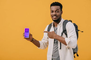 turuncu izole ekranda alışveriş uygulaması ile akıllı telefon parmak ile işaret neşeli afrikalı amerikalı adam 
