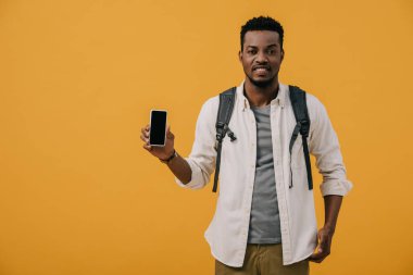 turuncu izole boş ekran ile akıllı telefon tutan mutlu afrikalı amerikalı adam 