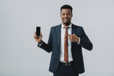 gri izole boş ekran ile akıllı telefon parmak ile işaret mutlu afrikalı Amerikalı işadamı 