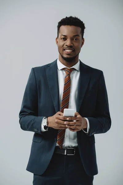 Позитивний Афроамериканський Чоловік Костюмі Використанням Смартфона Ізольовано Сірому — стокове фото