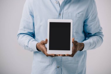 gri izole boş ekran ile dijital tablet tutan Afrikalı Amerikalı adam kırpılmış görünümü 