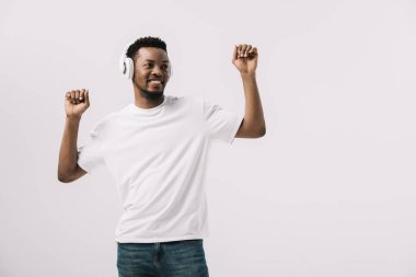 olumlu afro-amerikan adam kulaklık müzik dinleme ve gesturing beyaz izole 