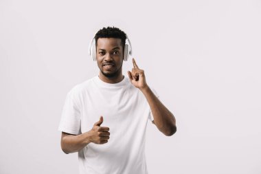 yakışıklı afro-amerikan adam müzik dinleme ve başparmak kadar beyaz izole gösteren 