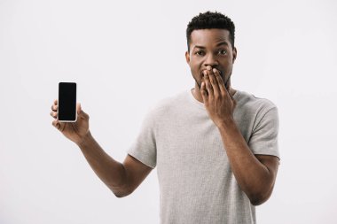 şok afrikalı amerikalı adam yüz kapsayan ve beyaz izole boş ekran ile akıllı telefon tutarak 