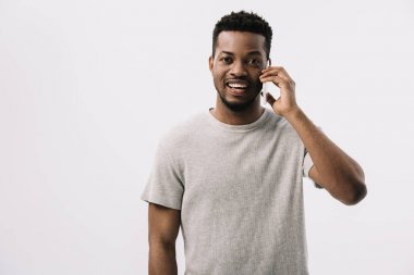 heyecanlı afro-amerikan adam gri izole akıllı telefonda konuşurken 