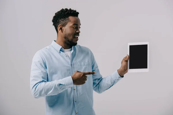 灰色で隔離された空白の画面を持つデジタルタブレットで指で指を指して幸せなアフリカ系アメリカ人の男性 — ストック写真
