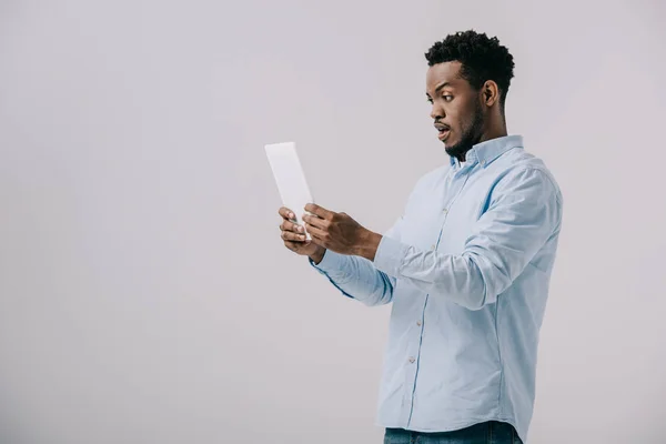 Hombre Afroamericano Sorprendido Sosteniendo Tableta Digital Aislado Gris —  Fotos de Stock