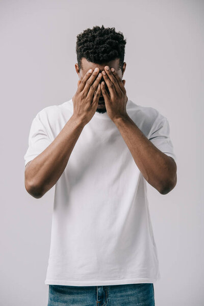 african american man covering face with hands isolated on grey 
