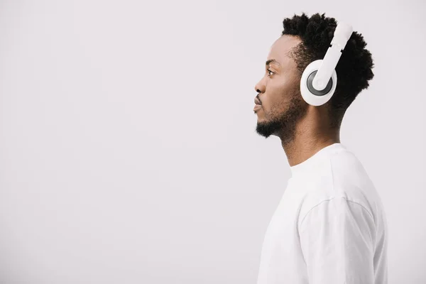 侧面视图非洲美国男子听音乐在耳机上的白色 — 图库照片