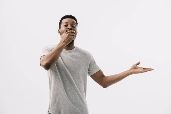 curly african american man covering face and gesturing isolated on white 