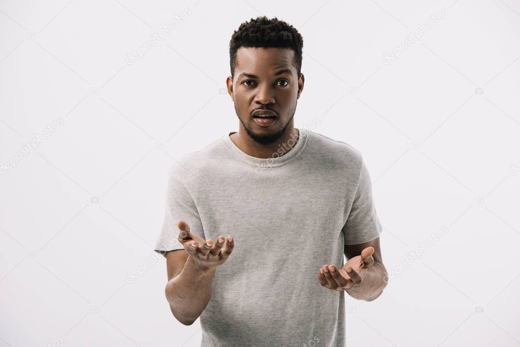 confused african american man gesturing and looking at camera isolated on white 